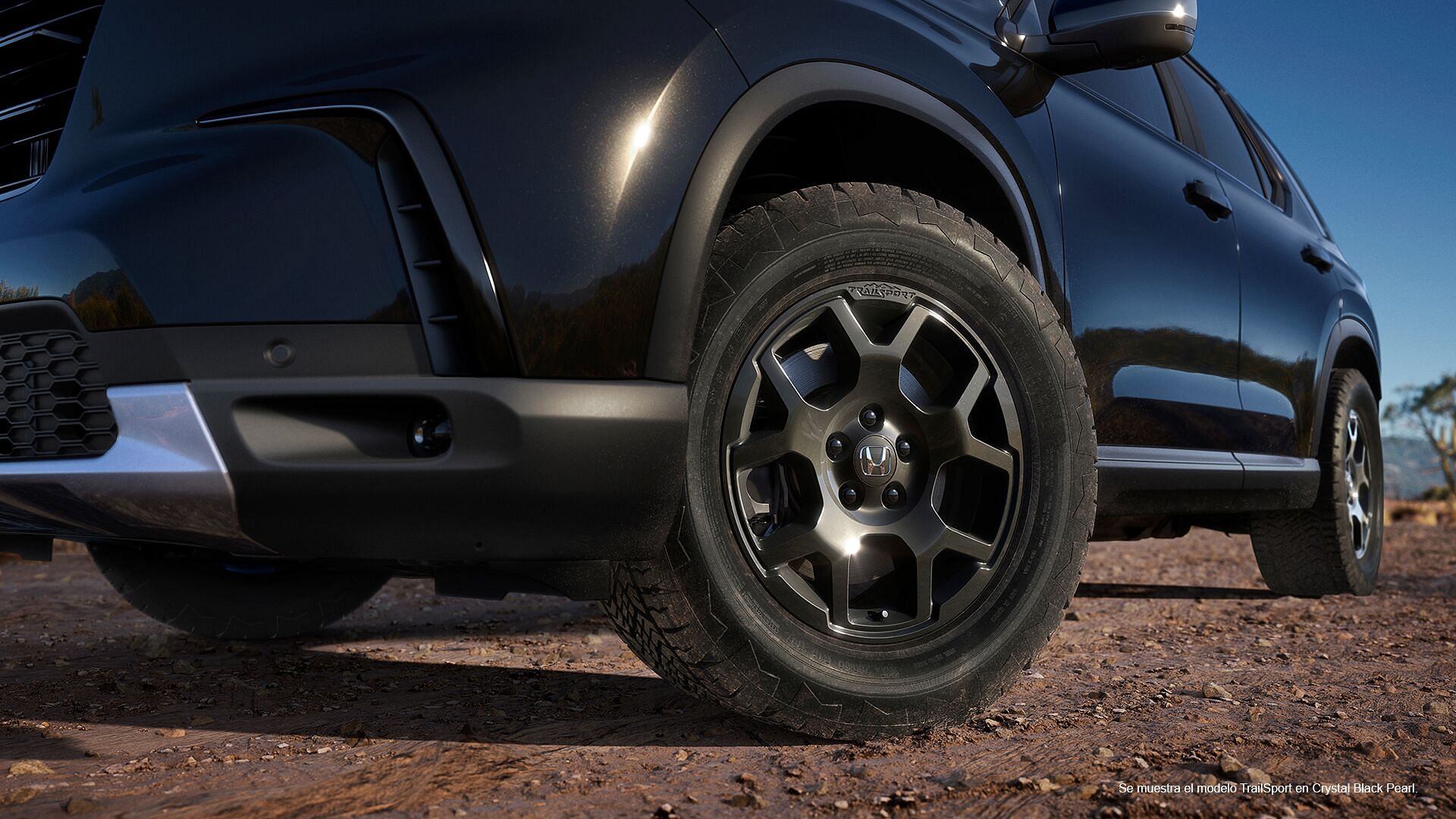 Un neumático de 2023 Honda Pilot TrailSport con el color exterior Crystal Black Pearl.